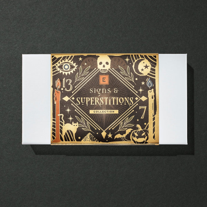 Christopher Elbow Signs and Superstitions 8-piece collection in its black and gold illustrated Halloween gift sleeve